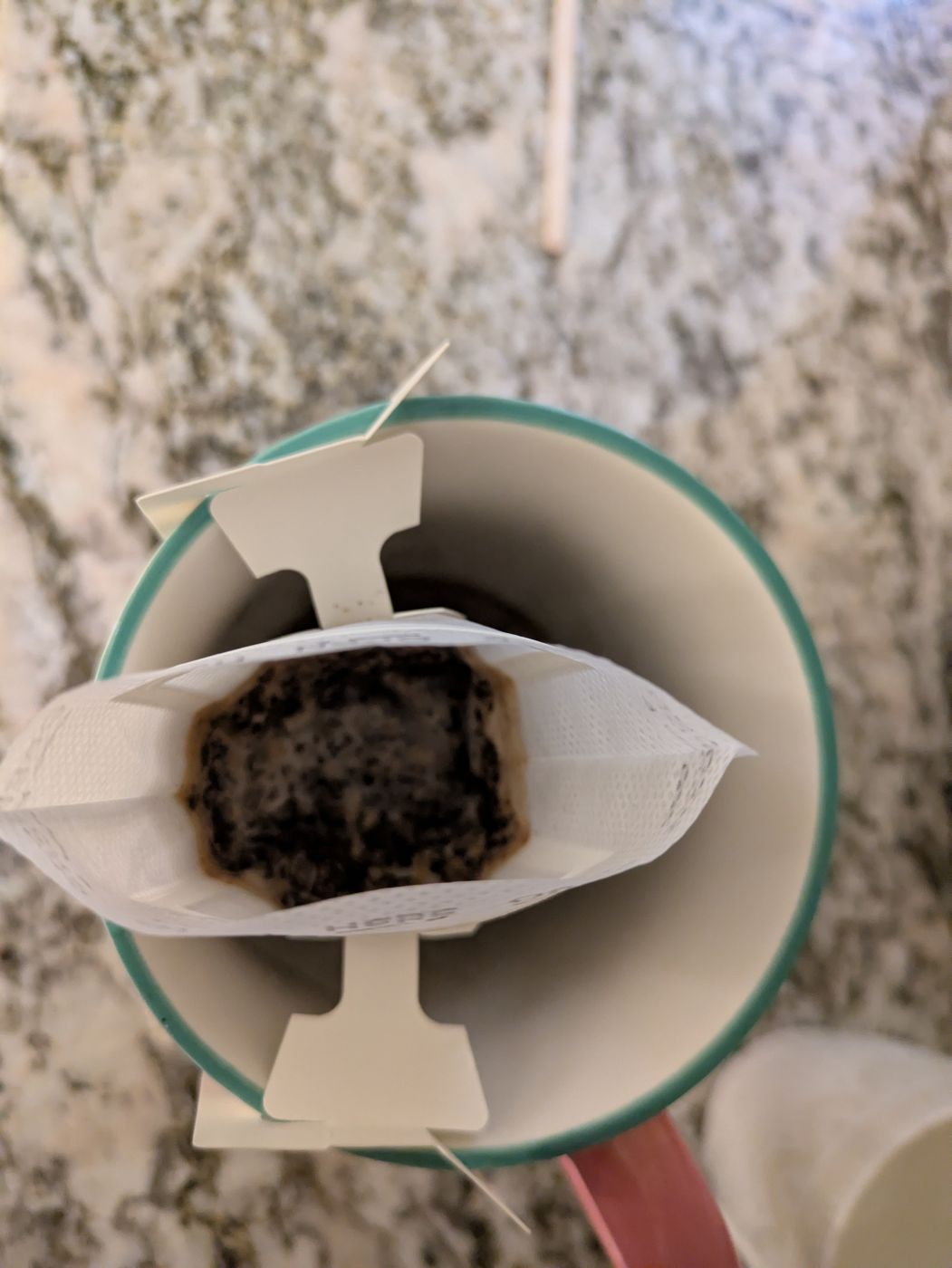 A filter sachet brewing over a cup